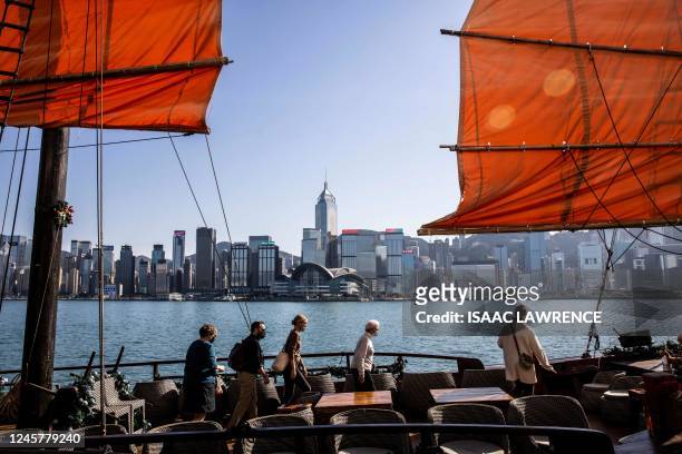 Passengers board a junk boat on Victoria Harbour in Hong Kong on December 22, 2022.