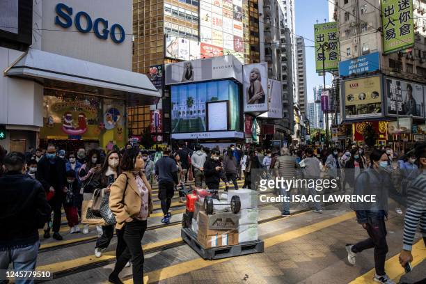 People walk through a shopping district in Hong Kong on December 22, 2022. - Hong Kong accused the United States of "totally unreasonable" trade...