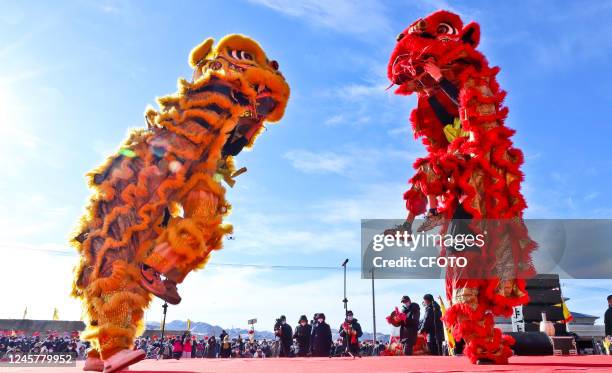 Tourists enjoy a lion dance performance in Qidian village, Qingquan town, Shandan county, Zhangye, Northwest China's Gansu province, Dec 22, 2022. It...
