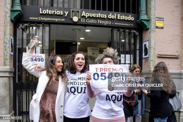 Lottery sellers of the "Gato Negro" celebrate after selling a winning ticket of the first prize of Spain's Christmas lottery "El Gordo" in Seville,...