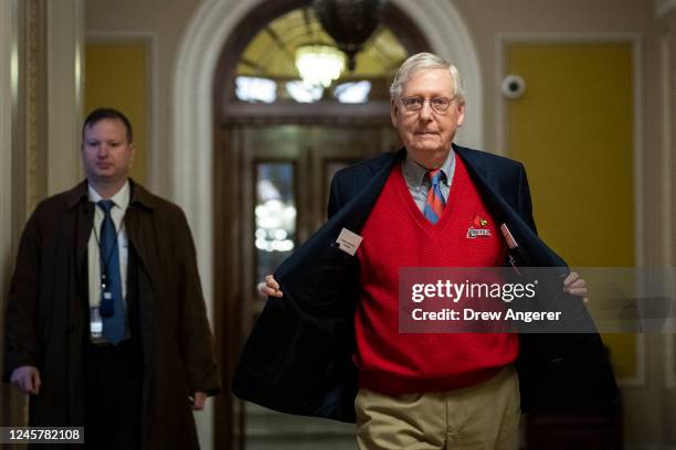 Senate Minority Leader Mitch McConnell shows his University of Louisville sweater as he walks from the Senate floor back to his office at the U.S....