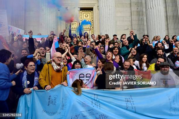 Activists light flares as they gather to celebrate after a vote in favour of a transgender rights bill in front of the Spanish Congress of Deputies...