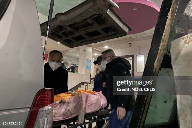 Funeral workers load a body to a cart to be cremated at a crematorium in China's southwestern city of Chongqing on December 22, 2022.