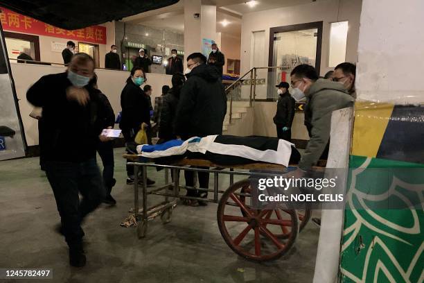 Funeral workers load a body to a cart to be cremated at a crematorium in China's southwestern city of Chongqing on December 22, 2022.