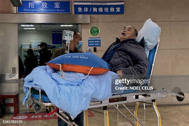 An elderly covid-19 coronavirus patient lies on a stretcher at the emergency ward of the First Affiliated Hospital of Chongqing Medical University in...