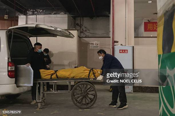 Funeral workers load a body to a cart to be cremated at a crematorium in China's southwestern city of Chongqing on December 22, 2022.
