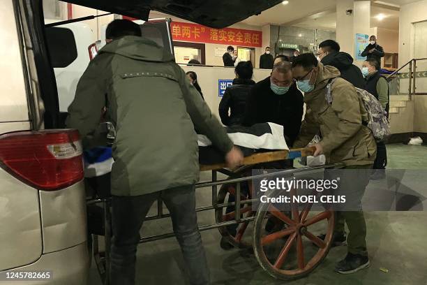 Funeral worker put a body to a cart to be cremated at a crematorium in China's southwestern city of Chongqing on December 22, 2022.