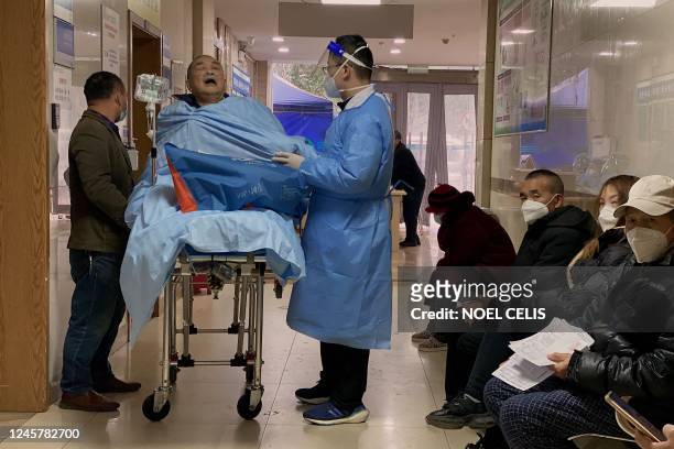 An elderly covid-19 patient lies on a stretcher at the emergency ward of the First Affiliated Hospital of Chongqing Medical University in China's...