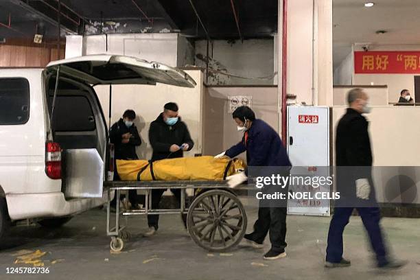 Funeral workers load a body to a cart to be cremated at a crematorium in China's southwestern city of Chongqing on December 22, 2022.