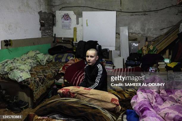 Hleb Petrova sits on his sleeping bed in a basement where he takes shelter and live with her family, relatives and neighbours seeking more protection...