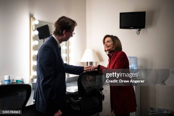 Speaker of the House Nancy Pelosi speaks with an aide in the green room before the start of her final weekly news conference at the U.S. Capitol on...