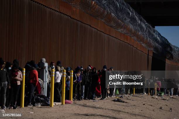 Migrants wait at the US and Mexico border wall in El Paso, Texas, US, on Thursday, Dec. 22, 2022. Chief Justice John Roberts temporarily blocked the...