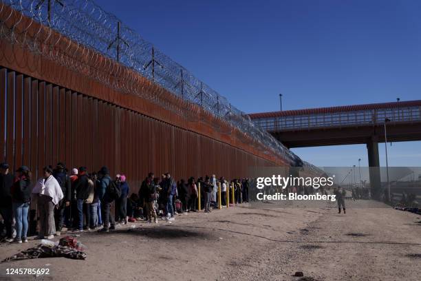 Migrants wait at the US and Mexico border wall in El Paso, Texas, US, on Thursday, Dec. 22, 2022. Chief Justice John Roberts temporarily blocked the...