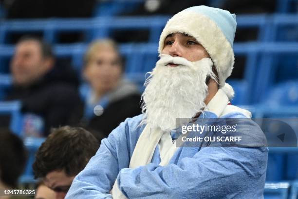 Manchester City fan wearing a Santa hat and beard waits for kick off during the English League Cup fourth round football match between Manchester...