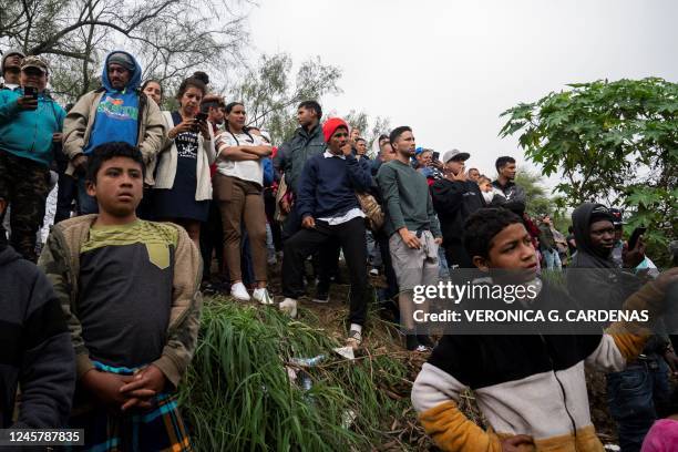 Asylum seekers watch others cross the Rio Grande into Brownsville, Texas, the day after Title 42 had been expected to be lifted but now the decision...