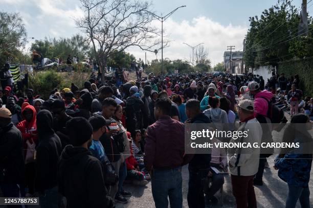 Asylum seekers wait in line to put their name on a list to get called when it is their turn to seek asylum in the US, the day after Title 42 had been...