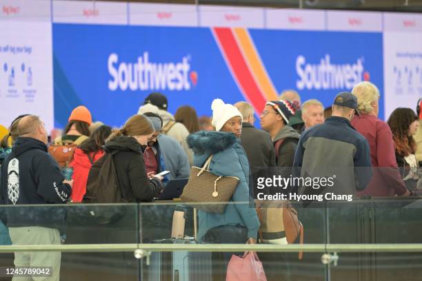 Khedive Preid , front, and Canceled flight travelers line for booking available flight at Denver International Airport in Denver, Colorado on...