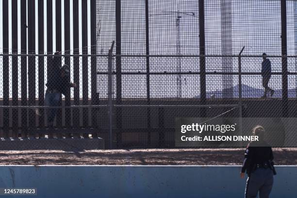 Migrant jumps over a fence back towards Mexico to evade US law enforcement after illegally crossing into the U.S. In El Paso, Texas, on December 22,...