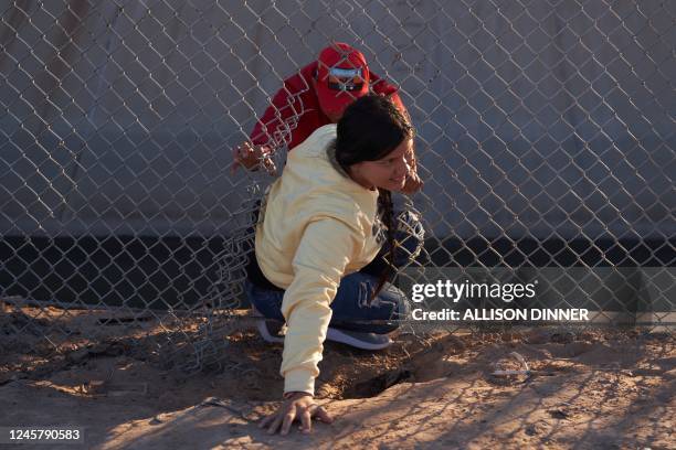 Migrants illegally cross into the United States via a hole in a fence in El Paso, Texas, on December 22, 2022. - The US Supreme Court on December 19,...