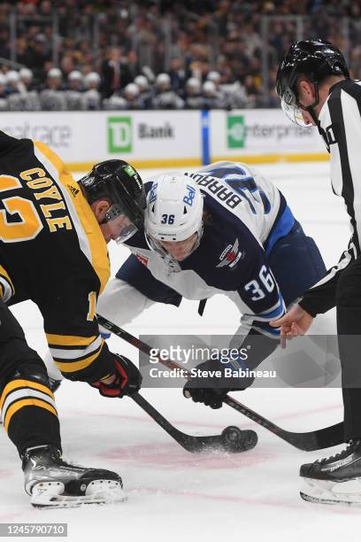 Charlie Coyle of the Boston Bruins faces off against Morgan Barron of the Winnipeg Jets at the TD Garden on December 22, 2022 in Boston,...