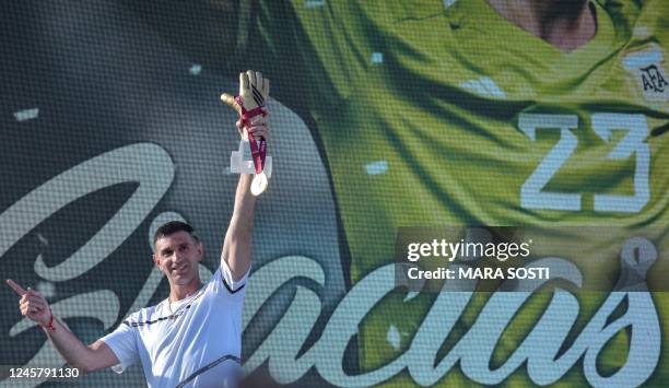 The goalkeeper of the Argentine soccer team Emiliano Martinez, holds gold medal and gold glove trophy awarded by FIFA during a tribute to him, in Mar...