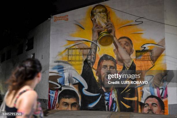 Mural by artist Maxi Bagnasco depicting Argentina's captain and forward Lionel Messi raising the FIFA World Cup Trophy next to his teammates after...