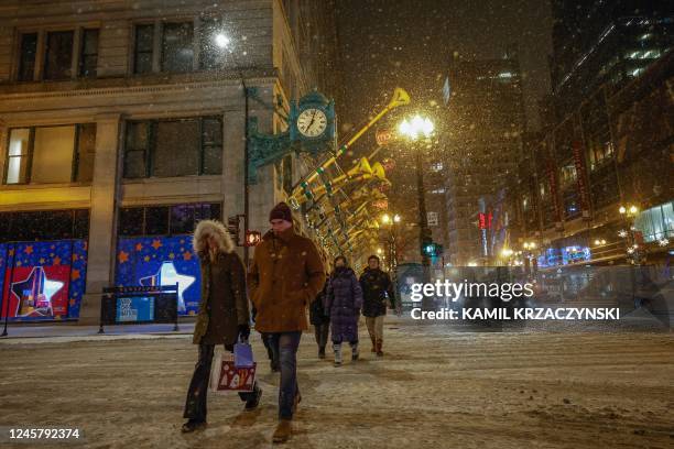 Pedestrians cross the street in Chicago, Illinois, on December 22 during a winter storm ahead of the Christmas holiday. - A "once-in-a-generation"...