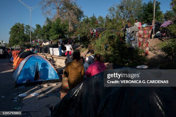 Migrants waiting to seek asylum in the United States pass their time at a migrant camp near the Gateway International Bridge in Matamoros,...