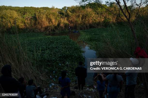 Migrants climb onto US soil to seek asylum after crossing the Rio Grande, as others watch them from the Mexican side of the river, in Matamoros,...