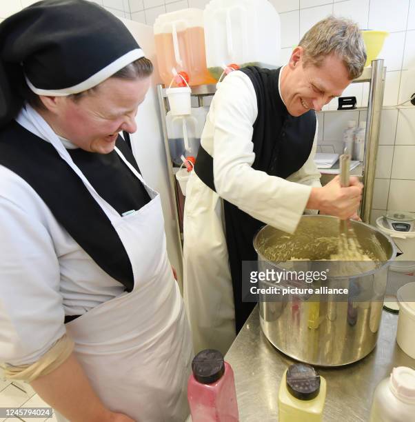 December 2022, Saxony-Anhalt, Helfta/Lutherstadt Eisleben: Laughing, nun Sister Gertrud watches her guest monk Father Justinus Pech of the Cistercian...