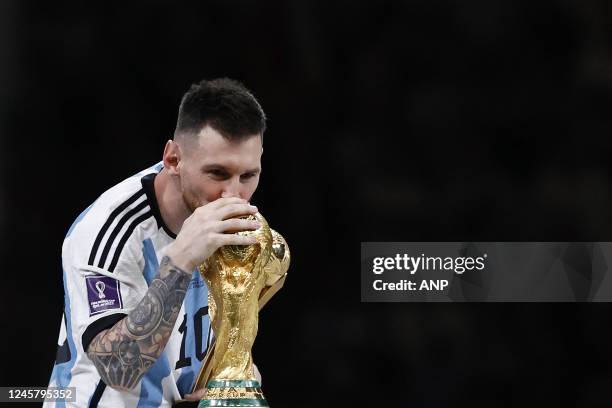 Lionel Messi of Argentina kisses the world cup trophy, FIFA World Cup Trophy during the FIFA World Cup Qatar 2022 final match between Argentina and...