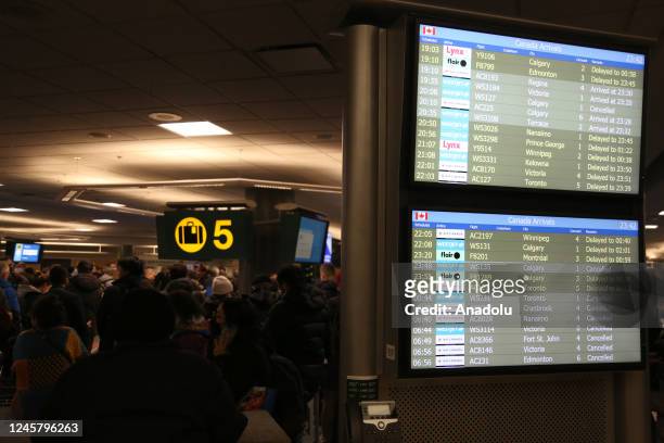 Board displaying flight information is seen at Vancouver International Airport on December 22, 2022 in Vancouver, BC, Canada. 115 flights out of 666...