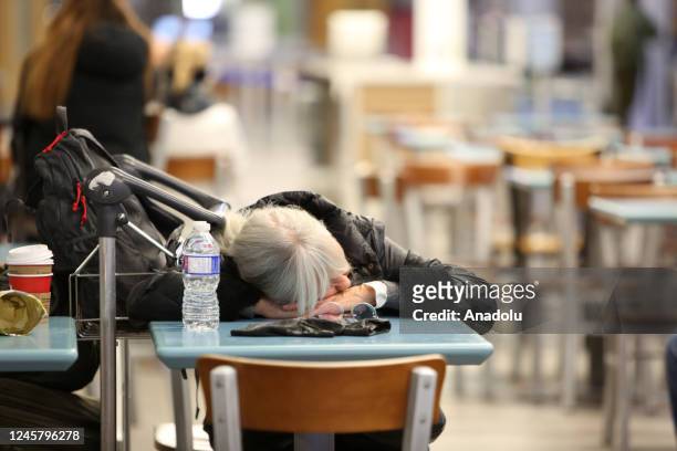Passenger sleeps at Vancouver International Airport after Thursday midnight on December 23, 2022 in Vancouver, BC, Canada. 115 flights out of 666...
