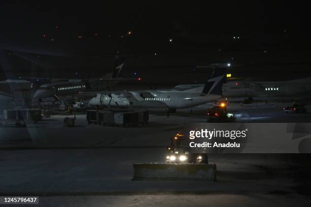 Vehicle shovel snow on the tarmac at Vancouver International Airport after Thursday midnight on December 23, 2022 in Vancouver, BC, Canada. 115...