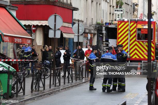 French security personnel secure the street after several shots were fired along rue d'Enghien in the 10th arrondissement, in Paris on December 23,...