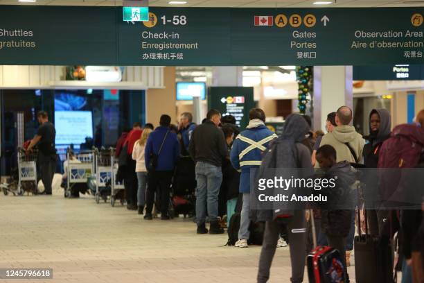 People wait at Vancouver International Airport after Thursday midnight on December 23, 2022 in Vancouver, BC, Canada. 115 flights out of 666 flights...