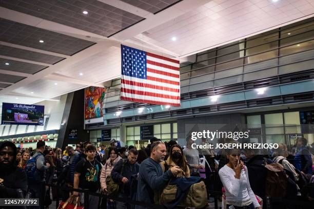 Travelers make their way through a security line at Logan International Airport in Boston, Massachusetts, on December 23, 2022. - A historic and...