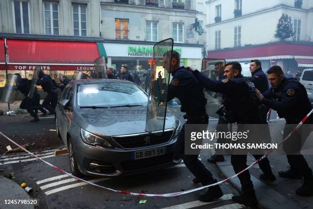 French riot police officers run to disperse protestors during a clash following a statement by French Interior Minister at the site where several...