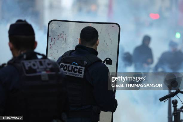 French riot police officers run to disperse protestors during a clash following a statement by French Interior Minister at the site where several...