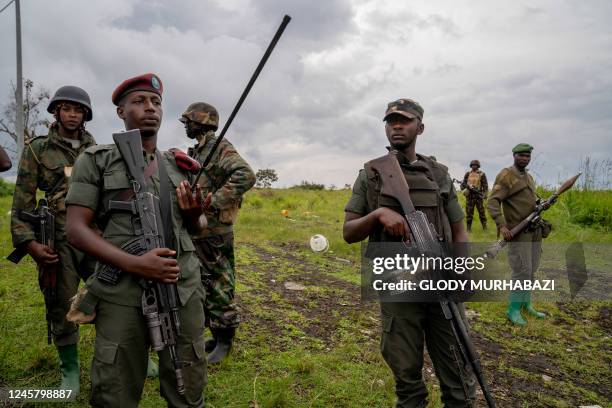 Rebels look on in Kibumba in eastern Democratic Republic of Congo, on December 23, 2022. - DR Congo's M23 rebels on December 23, 2022 met soldiers...