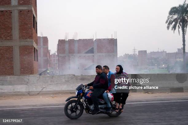 November 2022, Egypt, -: A motorcycle with 3 people is driving on a road between Cairo and Alexandria. Photo: Christophe Gateau/dpa