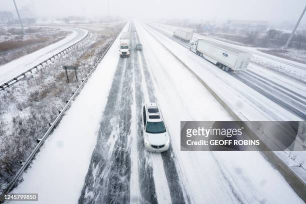 Traffic moves slowly along a snow-covered Highway 401 in London, Ontario, Canada, during a large winter storm on December 23, 2022. - Schools and...
