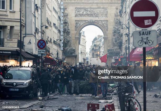 Protestors stand in front of riot police officers following a statement by French Interior Minister Gerald Darmanin at the site where several shots...