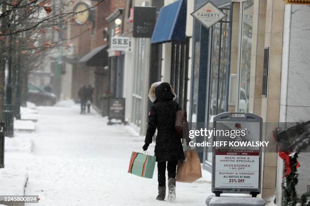 Shoppers brave the weather in downtown Birmingham, Michigan on December 23, 2022. - A historic and brutal winter storm put some 240 million Americans...