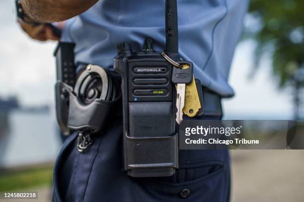 Chicago police officer stands with a police radio near Oak Street Beach on Aug. 18 in Chicago.