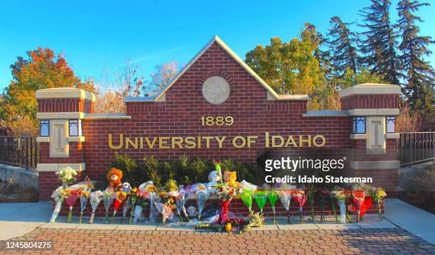 Flowers, notes and stuffed animals sit along the University of Idaho&apos;s entrance sign on Pullman Road in Moscow to honor the four students...