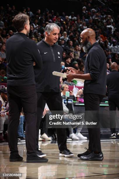 Head Coach Jacque Vaughn of the Brooklyn Nets draws up a play with Assistant Coach Igor Kokoskov and Assistant Coach Brian Keefe during a timeout on...