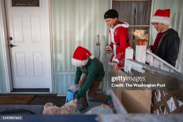 Eileen Ellis delivers gifts for donation to a mother named Lilian and her daughter Maylin with assistance from her sons Bryce Korbuly right, and Ian...