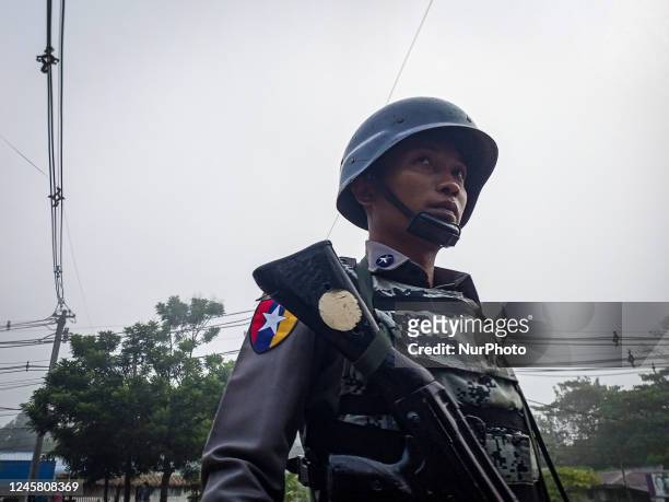 An armed policeman stands guard at the roadside during the visit of the Myanmar junta leader Min Aung Hlaing to Thanlyin township, on the outskirts...