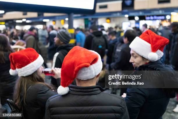 Family of three wearing Santa hats at London Euston train station on December 24, 2022 in London, England. Rail strikes over the Christmas period...